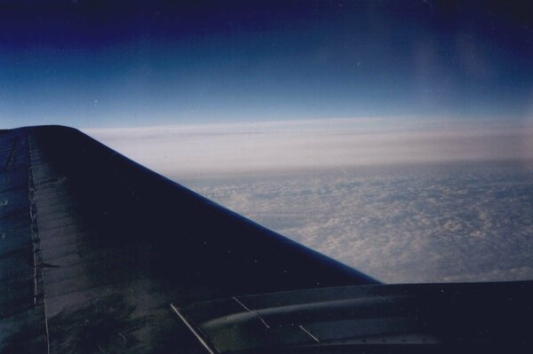 View from the porthole of the airplane wing and clouds