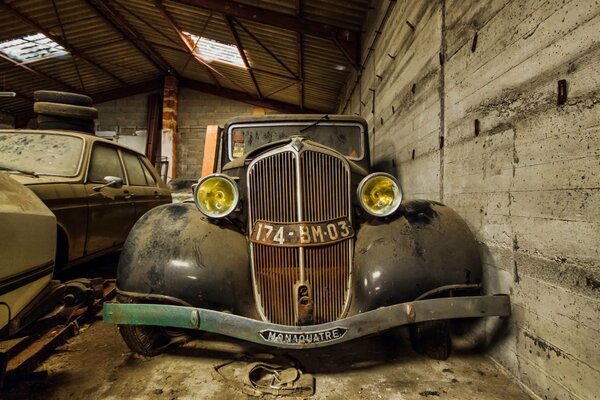 Старая машина в гараже для лома