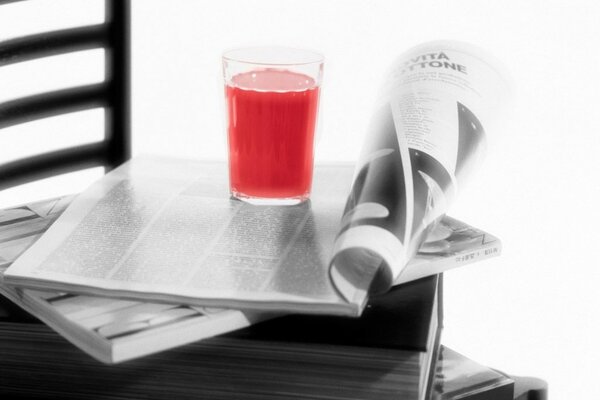 Magazin auf einem Stuhl mit Saft in einem Glas