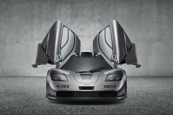 Vista frontale della McLaren grigia con porte aperte