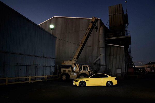 Coupé de voiture jaune à côté de la grue