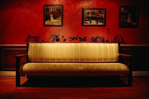 Antique sofa on the background of red walls with unusual patterns