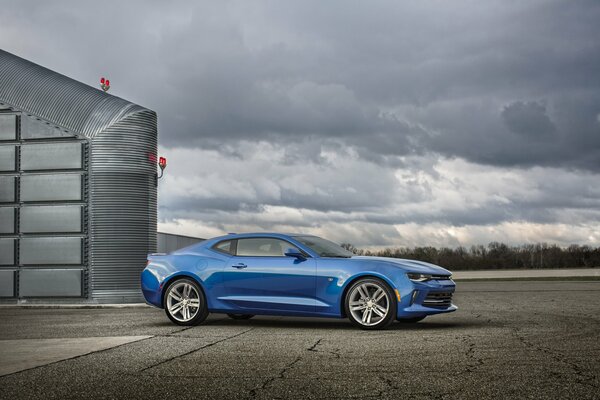 Niebieski Chevrolet Camaro RS 2015 na tle burzowego nieba