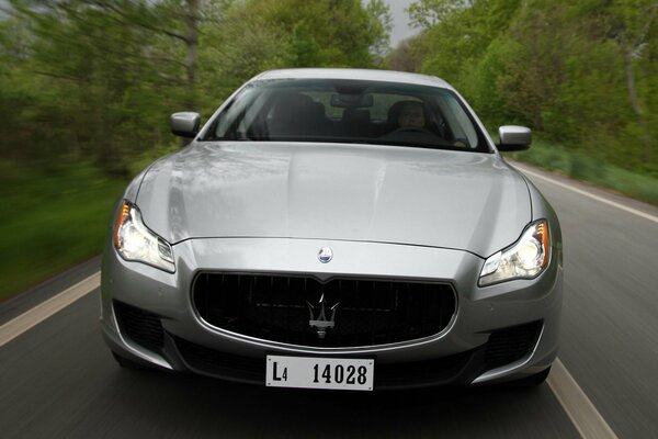 Grey maserati quattroporte s b4 rushes down the road front view