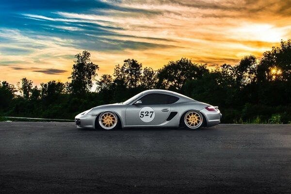 Porshe Cayman argenté au coucher du soleil