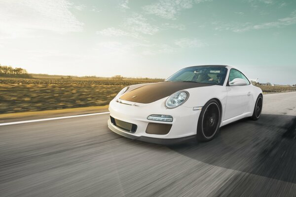 White Porsche with black hood on the highway