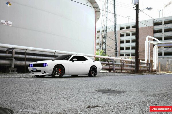 A white painted car is parked on the street