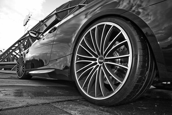 Black BMW on the background of a bridge in gray tons