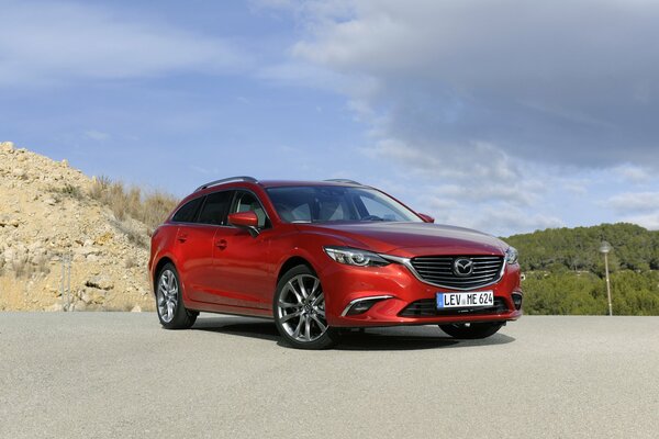 Brillante carmesí Mazda wagon en el asfalto