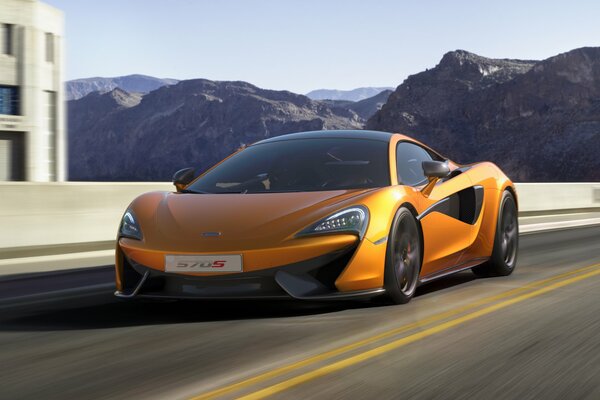 Orange mclaren in motion on a mountain road