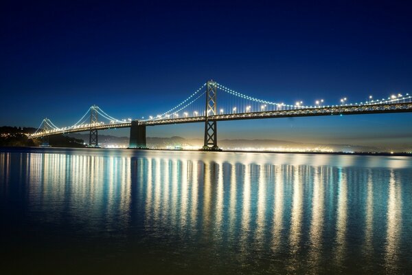 Nachts leuchten in San Francisco die Scheinwerfer auf der Brücke