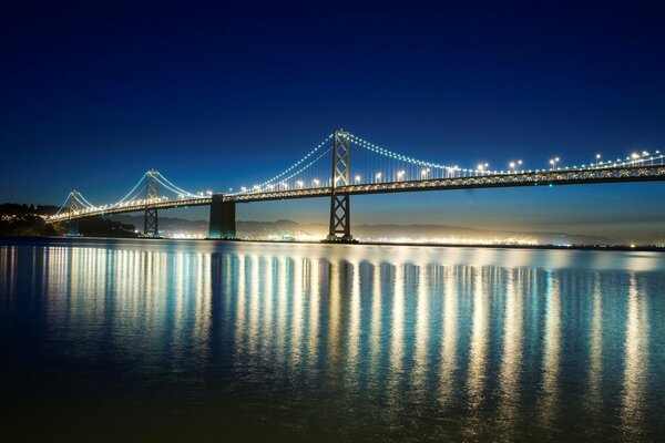 Headlights shine on the bridge at night in San Francisco