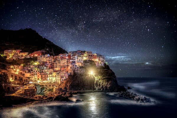 The sea, the starry sky and the old Italian town