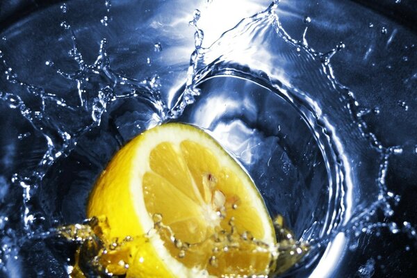 Lemon in splashes of water thrown into tea