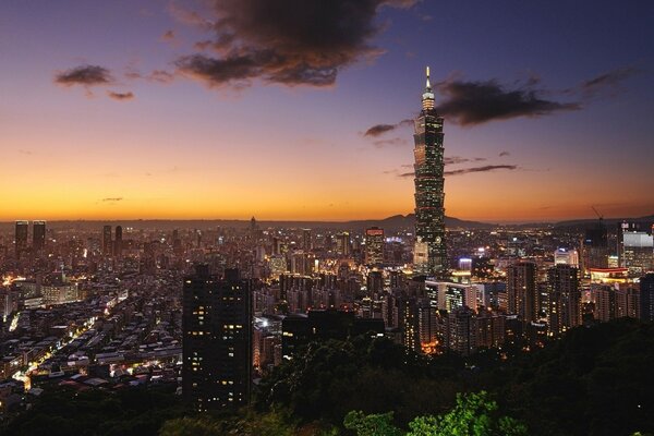 A city with a skyscraper at sunset