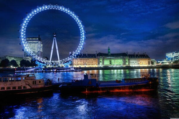 Grande roue et lumières de nuit dans le reflet de la rivière