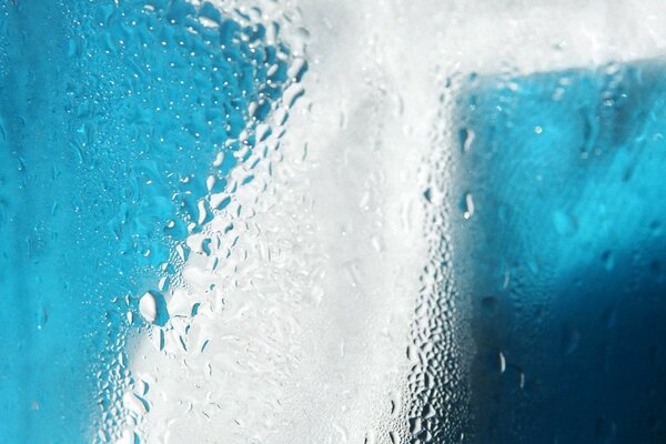 Wassertropfen auf blauem Glas