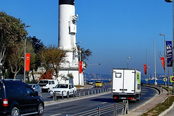 A road with cars on the background of a lighthouse