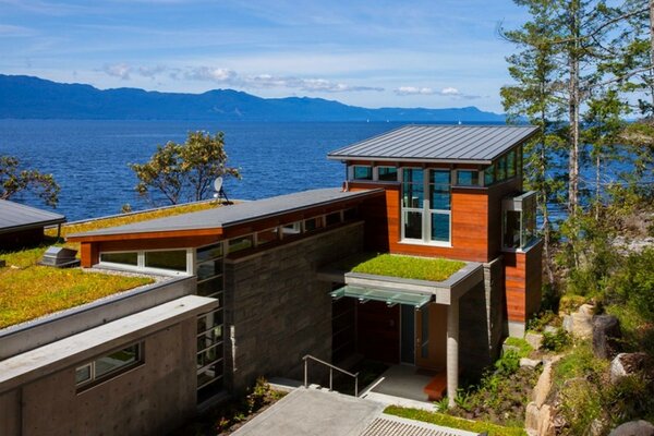 An architectural house with a background of the sea and mountains