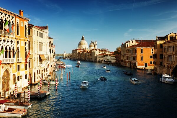 Photo of a river in Italy with boats near houses