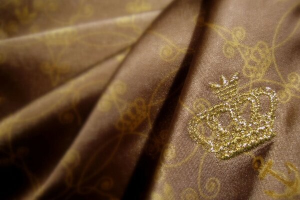 Изображение короны на ткани из золота