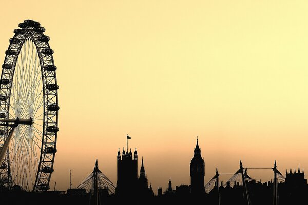 Silhouettes of the London Eye and Big Ben in the yellow sky