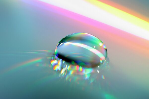 Glare from water on a smooth surface. The light spectrum reflected from the drop. A vivid snapshot of a drop