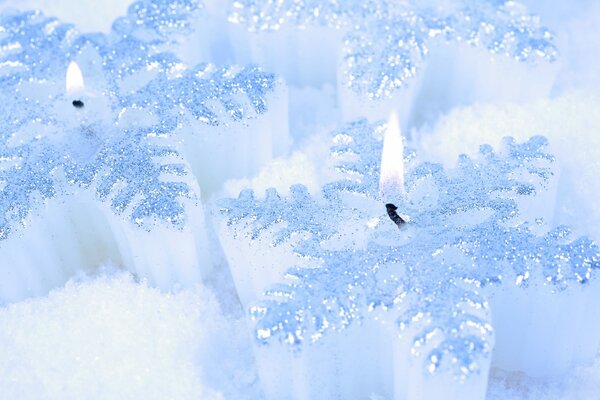 Candele a forma di fiocchi di neve sulla neve