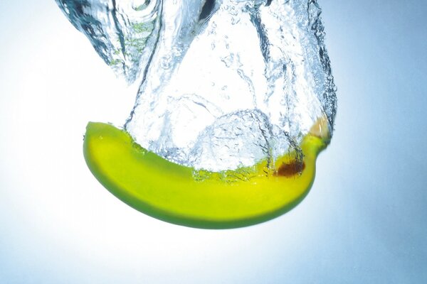 Yellow banana submerging in water