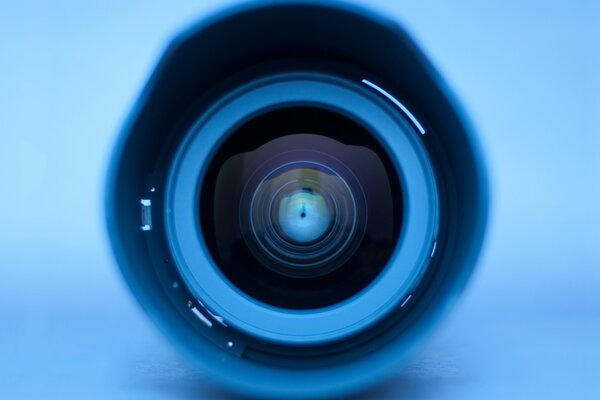 Large camera lens on a blue background