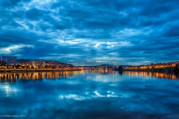 Reflejo de una ciudad Española nocturna en el río