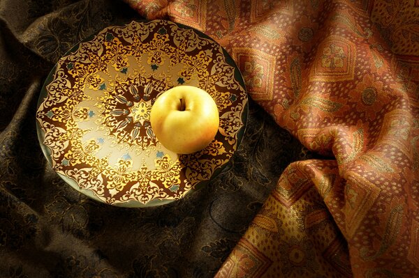 Manzana dorada en un platillo brillante
