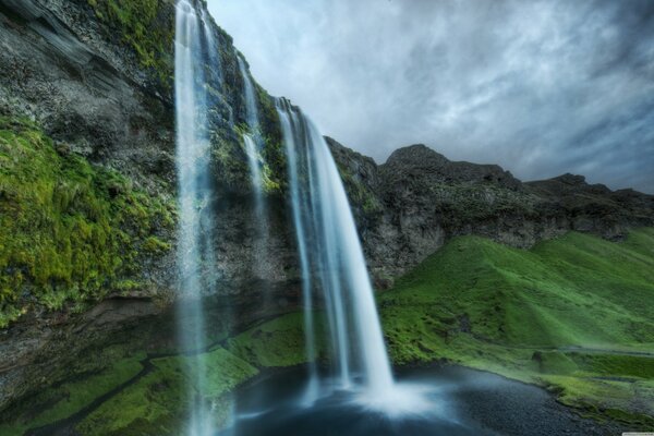Waterfall and green hills of Iceland