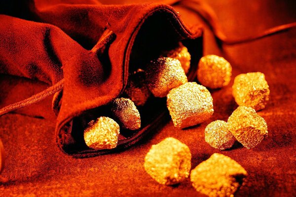 Small stones of gold on a red background