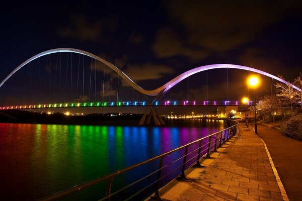 Luces del arco iris en el puente sobre el río