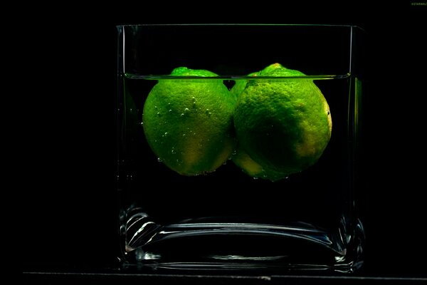 Deux limes dans un verre sur fond noir