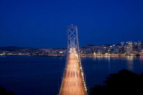 Puente en las luces en el fondo de la ciudad de la noche