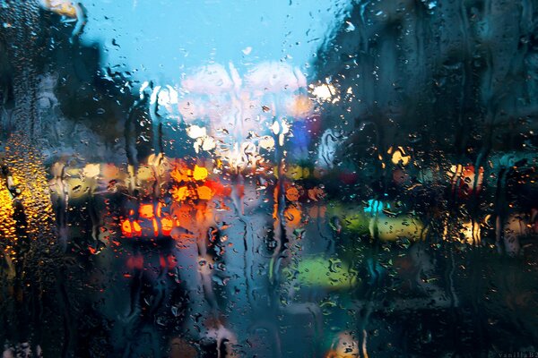 Raindrops on the glass against the background of city lights