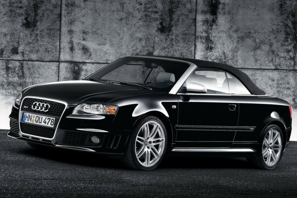 Черный Audi на фоне стены
