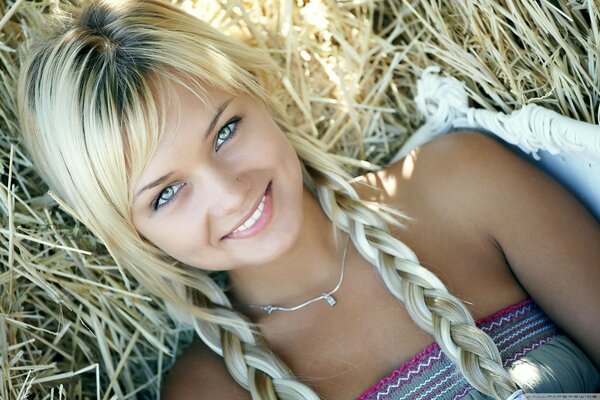 Jeune blonde aux yeux verts sur l herbe sèche