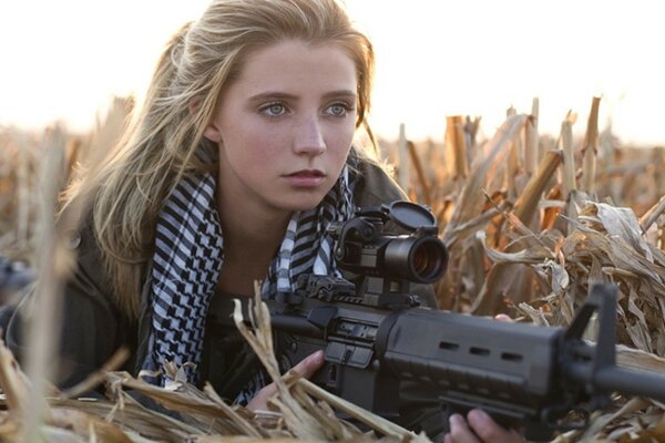 Fille blonde avec une mitraillette dans les mains