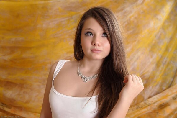 Portrait of a young girl in a white T-shirt with a necklace around her neck