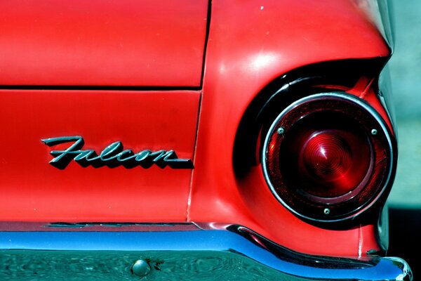 Arrière de voiture rouge avec un phare et logo