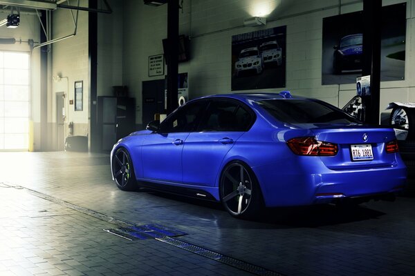 Blauer 3er BMW steht in einer Autowerkstatt