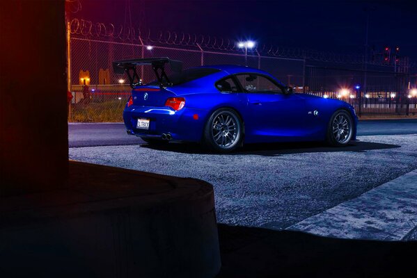 BMW azul en las luces de la ciudad nocturna