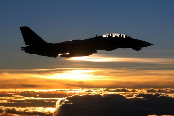 Fighter jet on the background of clouds and sunset