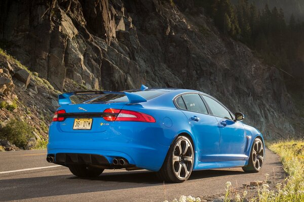 Blue sedan on a mountain road