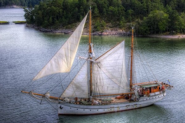 A sailboat sails past the island