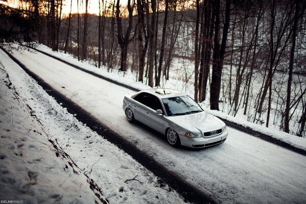 Audi a4 on a snowy road in the middle of the forest