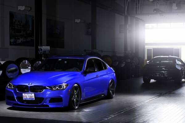 Blue BMW 3 Series, front view. Black car rear view